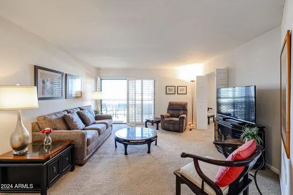 a living room with furniture a flat screen tv and a window