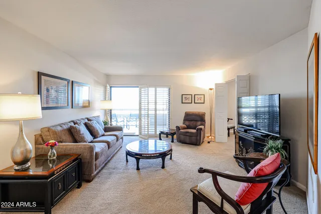 a living room with furniture a flat screen tv and a window