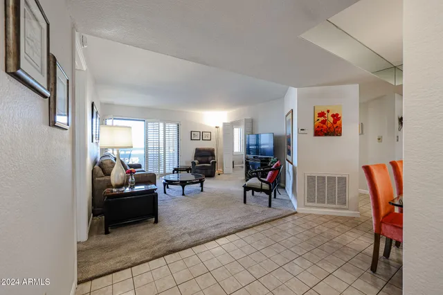 a living room with furniture a chandelier and a dining table