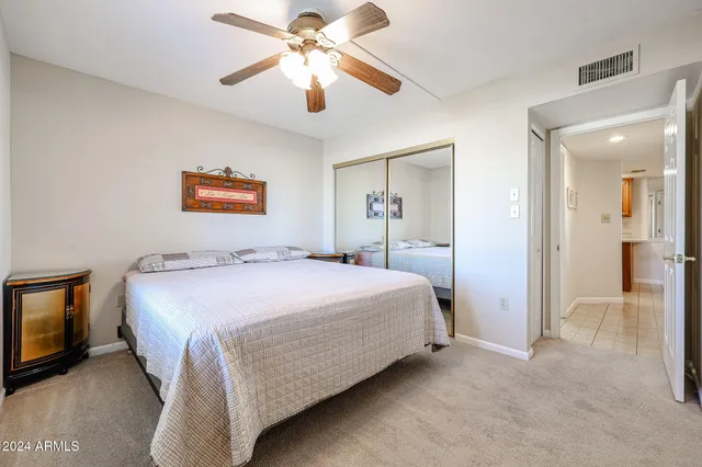 a spacious bedroom with a bed and a chandelier