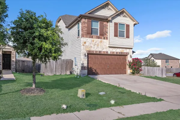 a front view of a house with a yard and garage