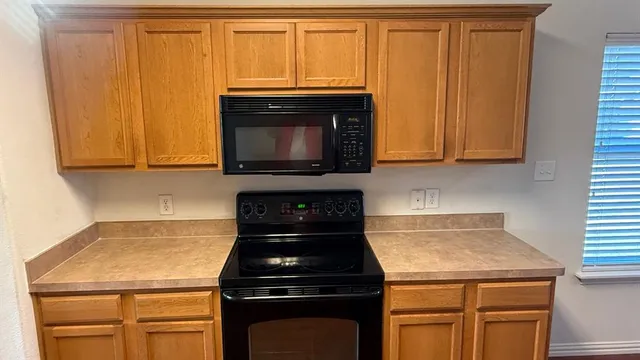 a kitchen with wooden cabinets and a stove top oven