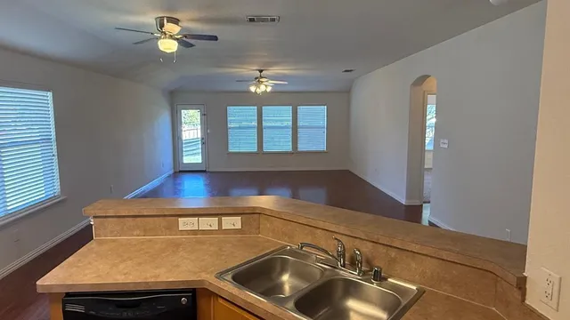 a view of a backyard with a large tree and wooden fence