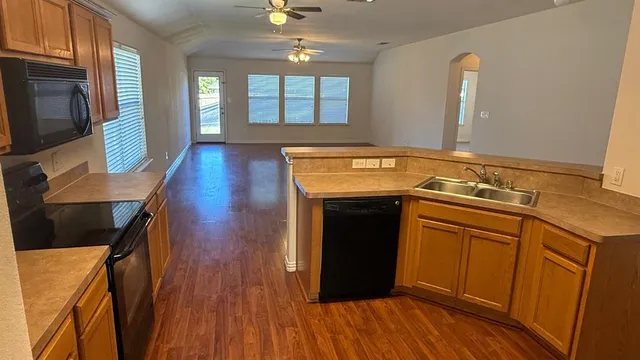 a view of a livingroom with a large window wooden floor and chandelier