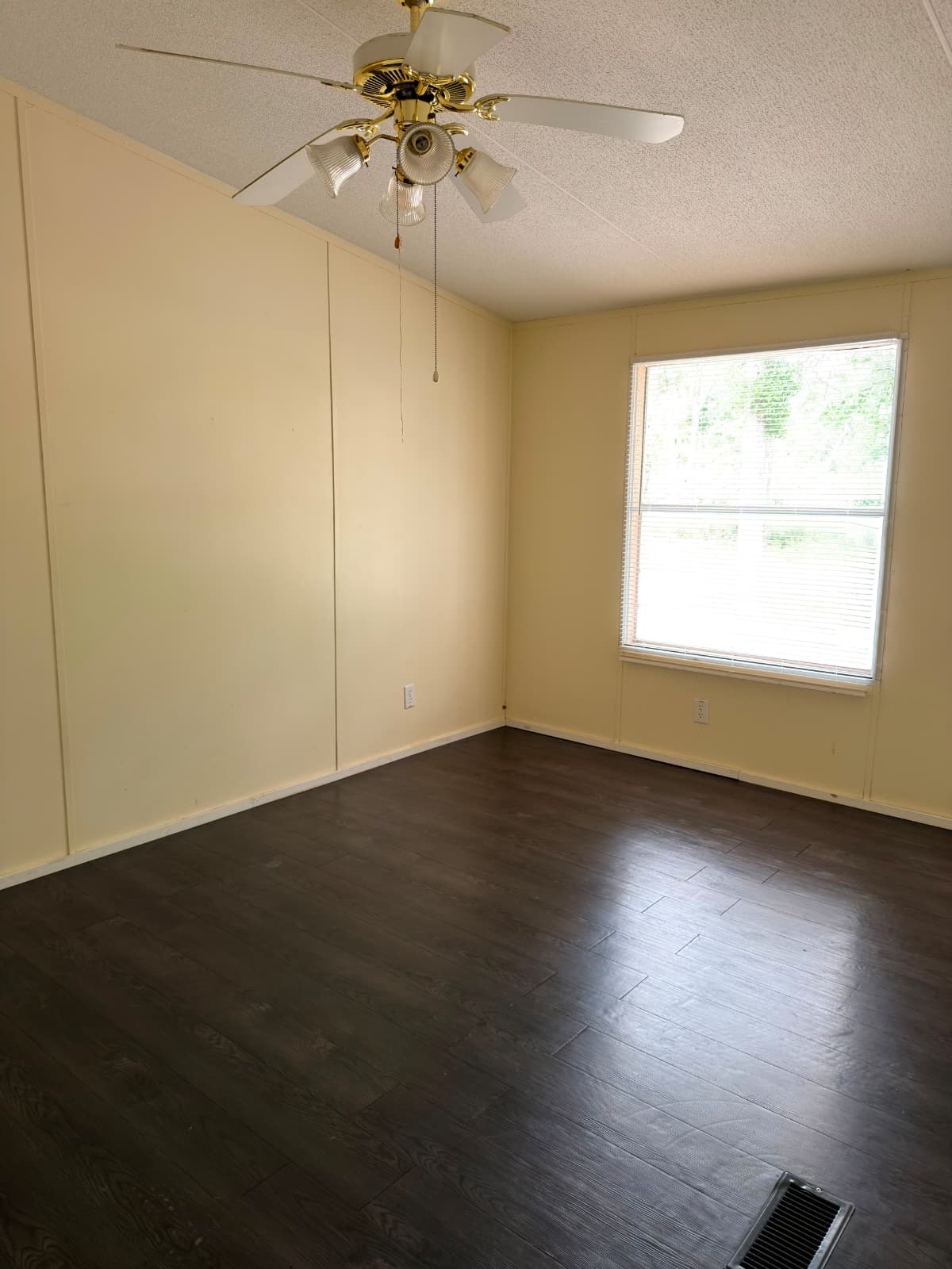 8607 Burleson Manor Road, Unit A Manor, TX 78653 - Photo 6 of 13 Well-lit room featuring dark wood-like flooring and a ceiling fan with integrated lighting.