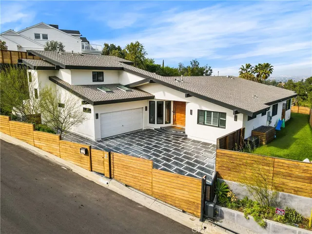 a front view of a house with a garden