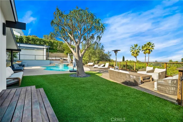 an aerial view of a house with swimming pool and outdoor seating
