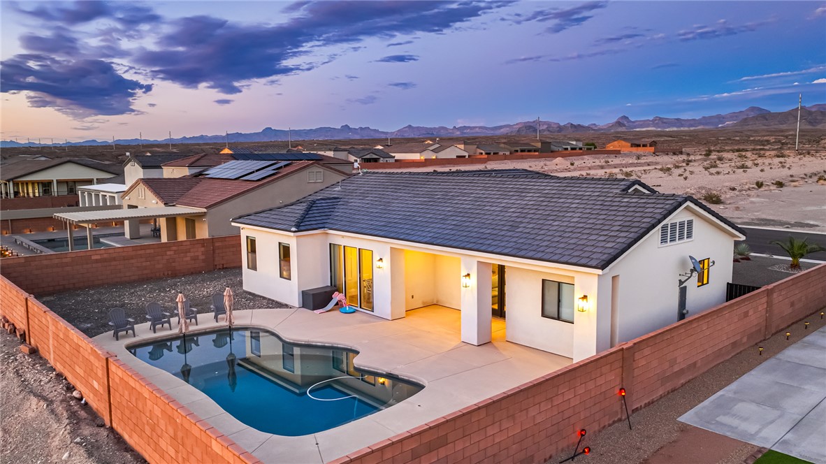 3783 Ramsey Road Bullhead City, AZ 86442 - Photo 50 of 56 Back of house at dusk with a fenced backyard, stucco siding, a patio, and a tile roof