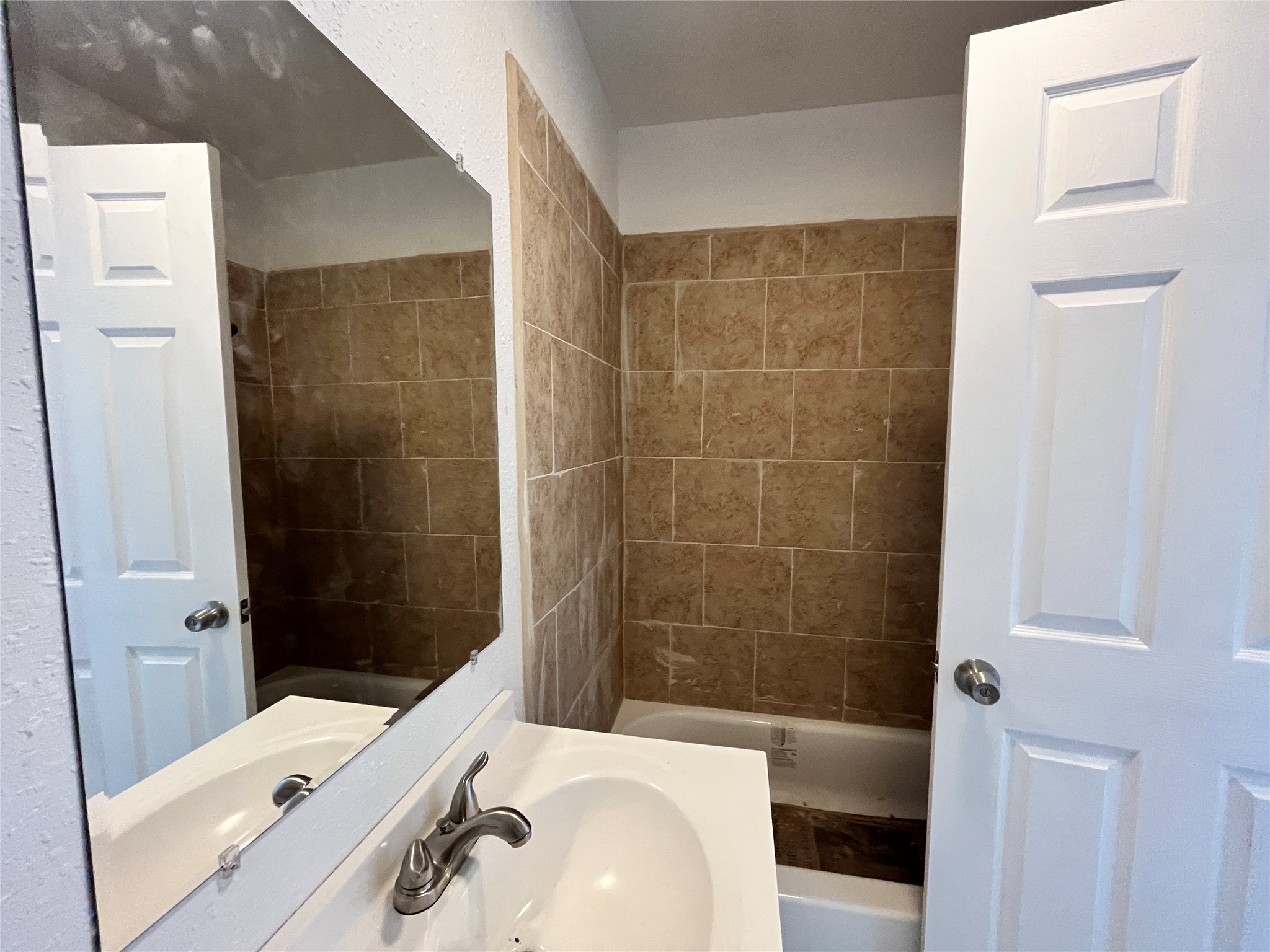 5104 39th Street East, Unit 4 Dickinson, TX 77539 - Photo 3 of 7 a bathroom with a sink a toilet and shower