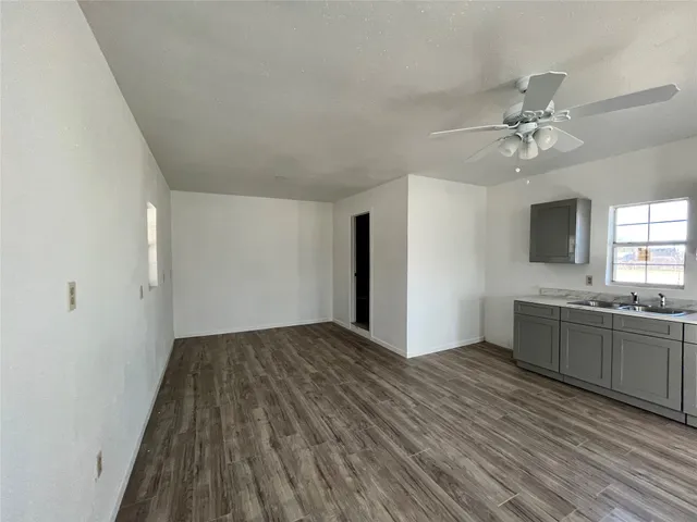 wooden floor in an empty room with a kitchen