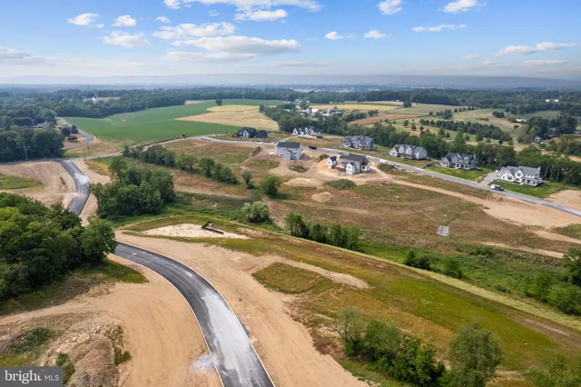an aerial view of residential houses with outdoor space and street view