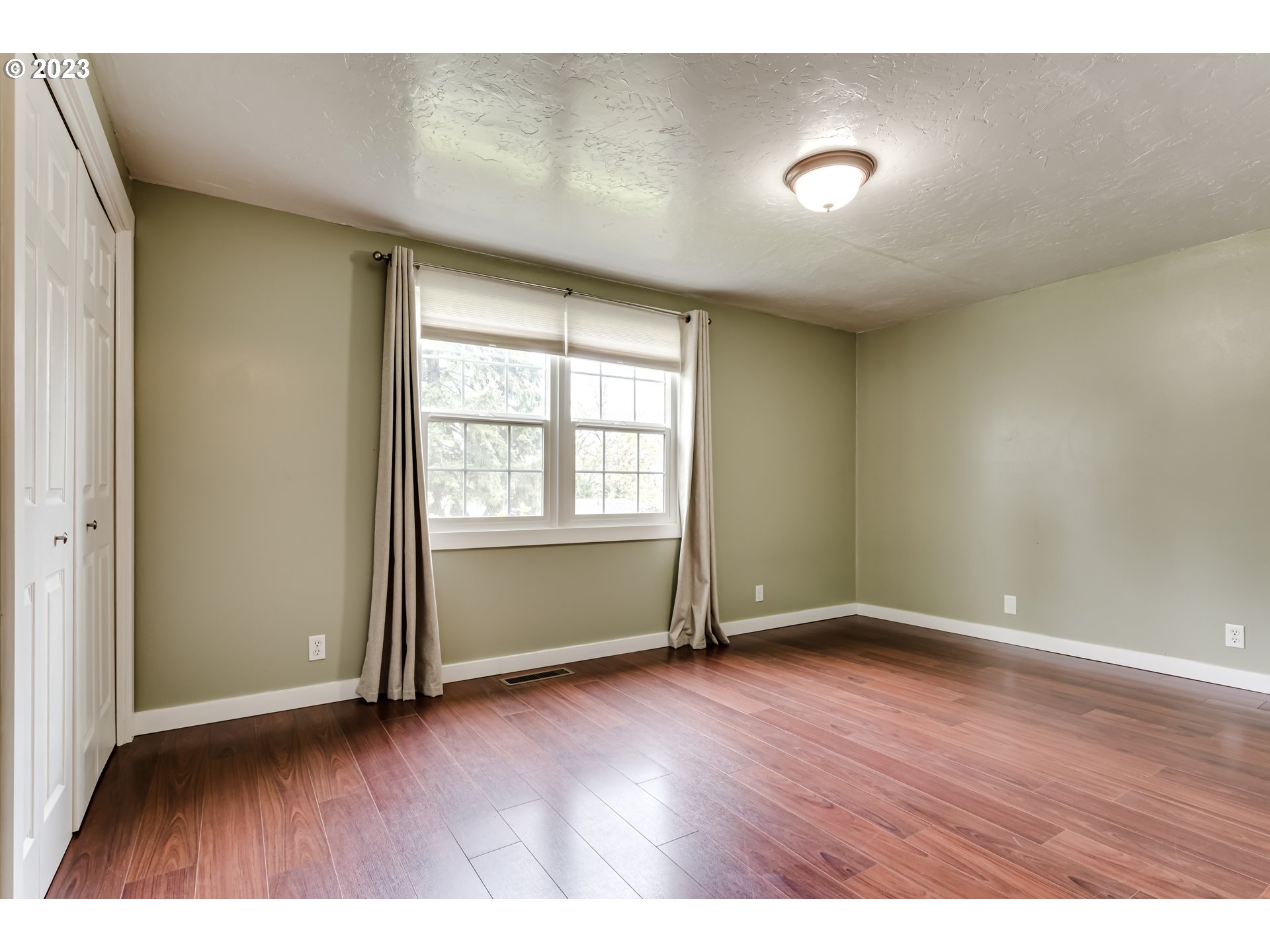 6973 Glacier Drive Springfield, OR 97478 - Photo 21 of 34 an empty room with wooden floor and windows