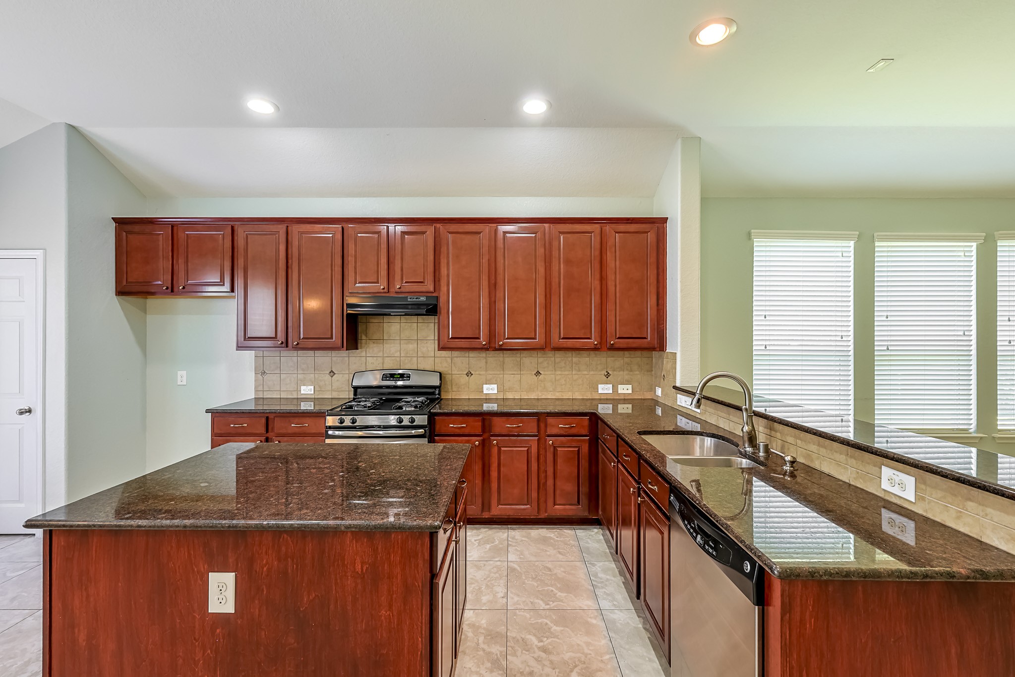 6014 Watford Bend Rosenberg, TX 77471 - Photo 8 of 36 a kitchen with a sink a counter top space cabinets and stainless steel appliances