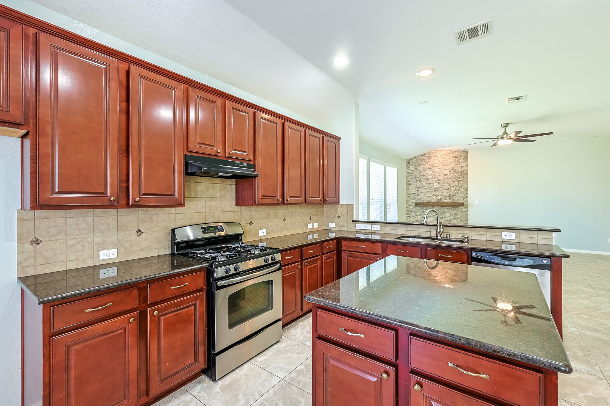 6014 Watford Bend Rosenberg, TX 77471 - Photo 9 of 36 a kitchen with stainless steel appliances granite countertop wooden cabinets a stove top oven a sink and dishwasher