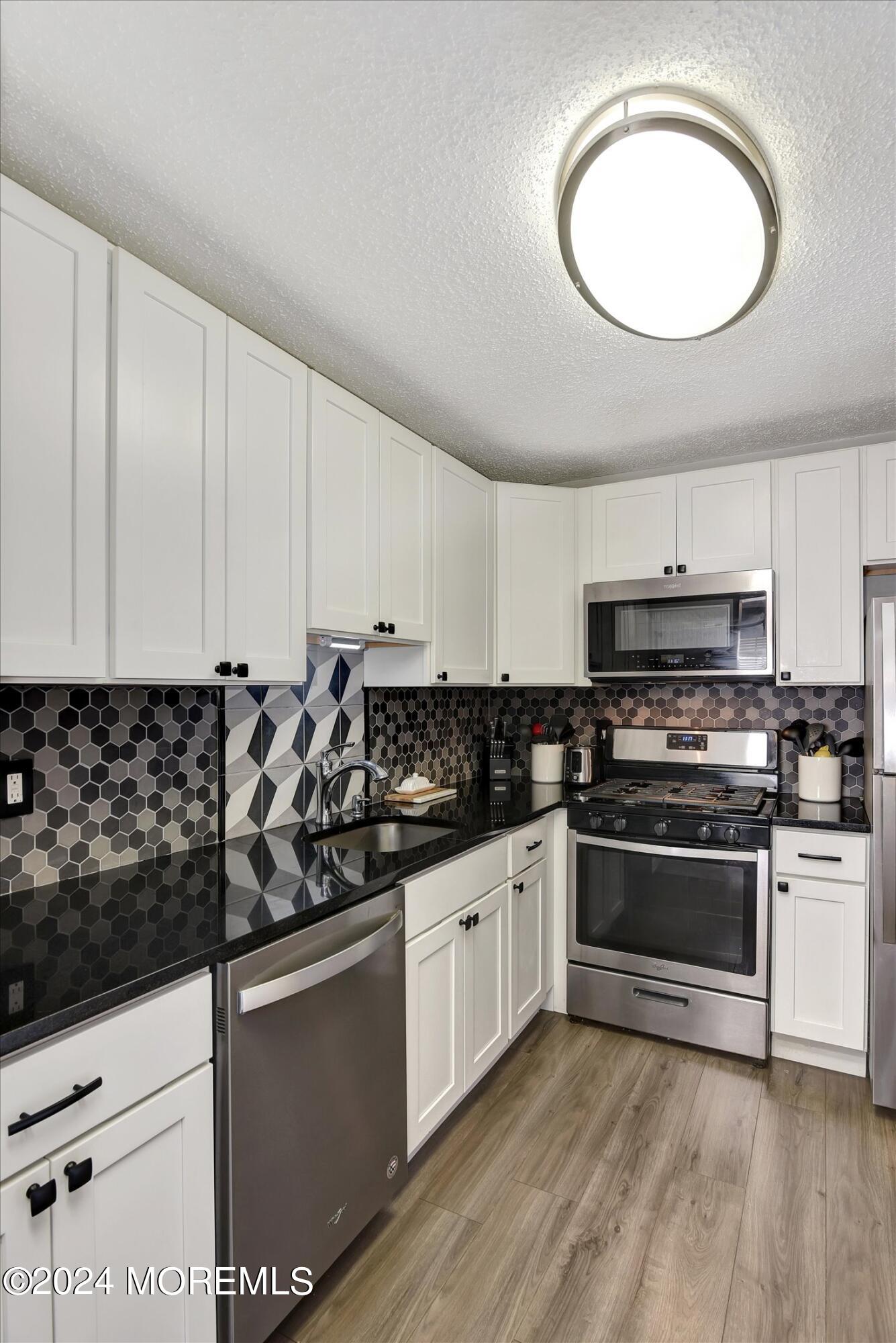 116 Azalea Circle Jackson, NJ 08527 - Photo 15 of 37 a kitchen with stainless steel appliances a stove a sink and a microwave
