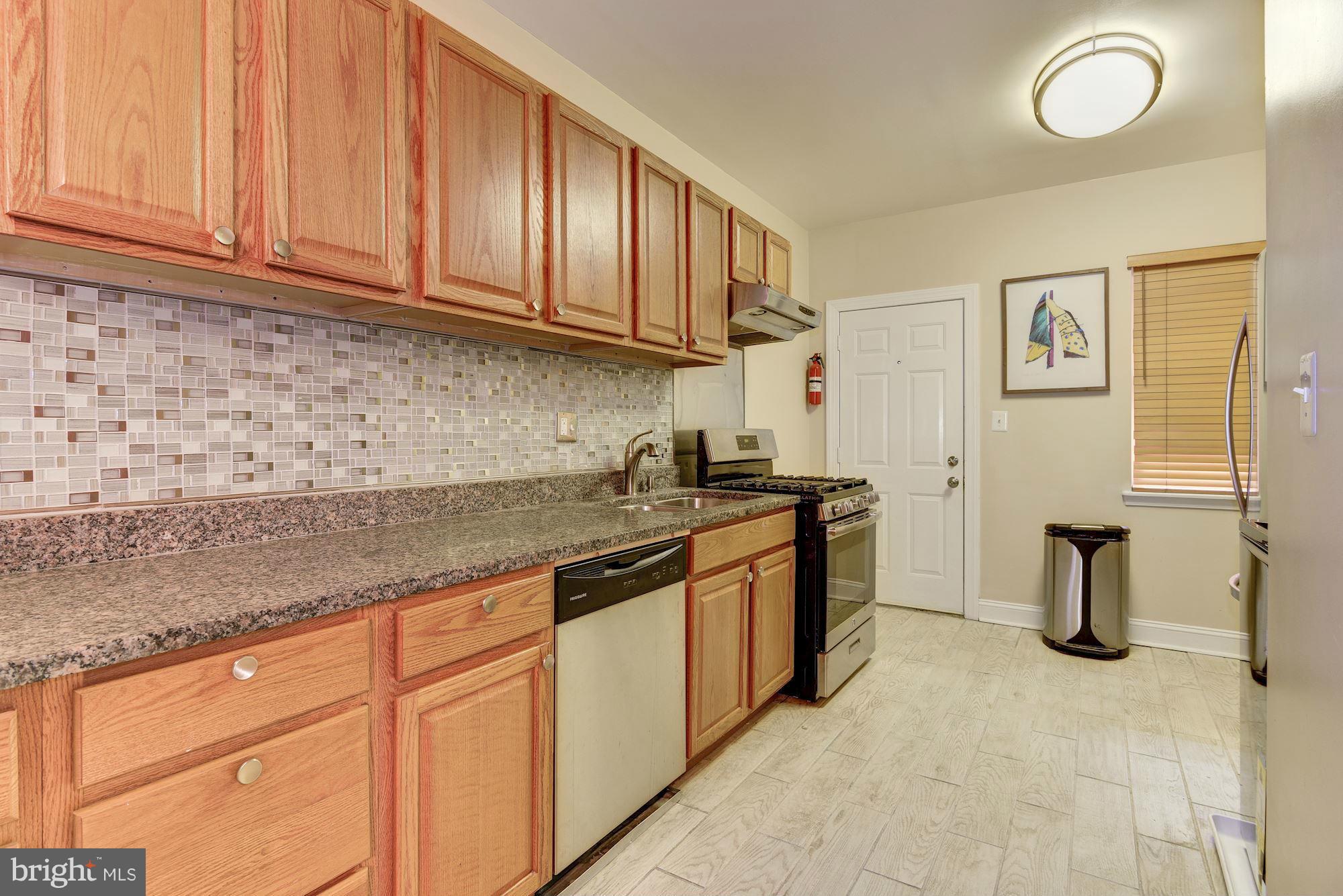 3633 13th Street Northwest Washington, DC 20010 - Photo 14 of 30 a kitchen with stainless steel appliances granite countertop a sink and cabinets