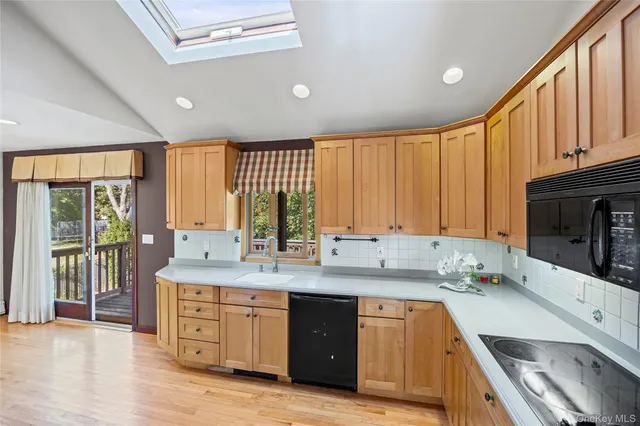a kitchen with stainless steel appliances granite countertop a sink a stove and cabinets