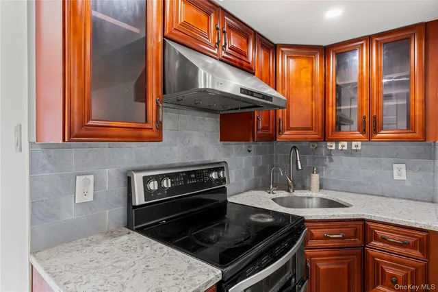 a kitchen with stainless steel appliances granite countertop a stove a sink and a microwave
