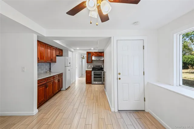 a view of a kitchen center island wooden floor and stainless steel appliances