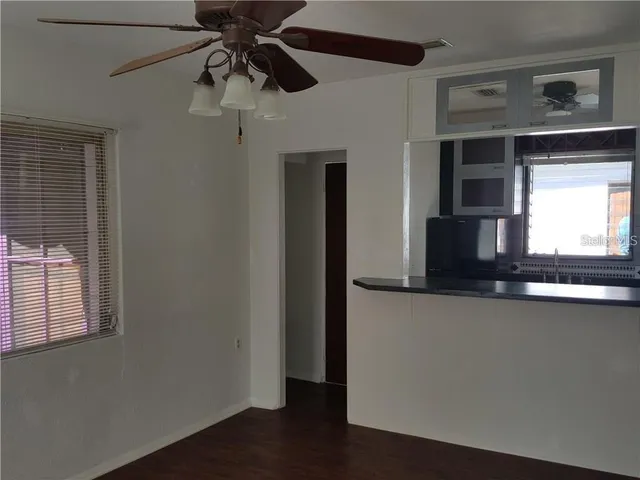 a view of a hallway with wooden floor and a cabinet