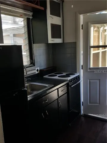 a kitchen with a refrigerator and a sink