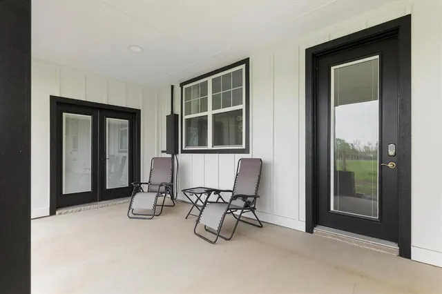 a view of an empty room with furniture and a window
