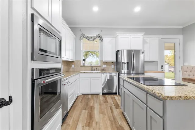 a kitchen with refrigerator cabinets and wooden floor