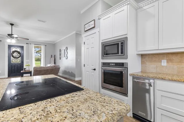 a kitchen with stainless steel appliances granite countertop a stove a microwave and a refrigerator