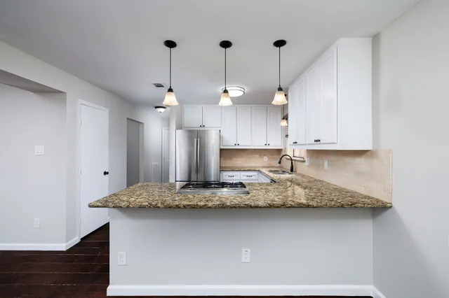 a kitchen with kitchen island a counter top space a sink stainless steel appliances and cabinets