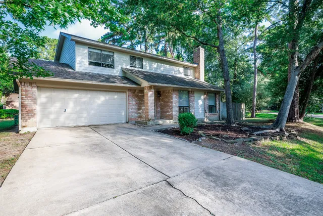 a front view of a house with a garden and trees