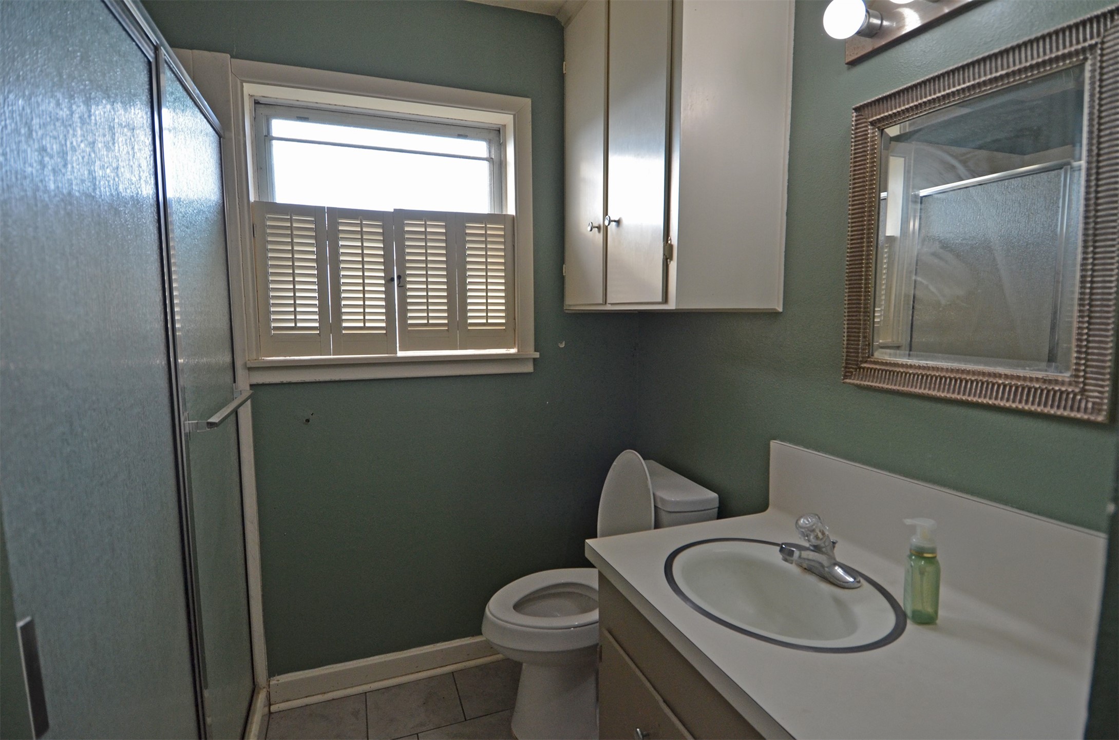 2352 Airport Road Brenham, TX 77833 - Photo 14 of 26 a bathroom with a granite countertop toilet a sink and a mirror