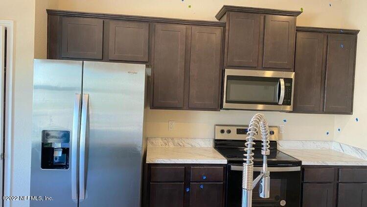 a kitchen with a sink a microwave a refrigerator and cabinets