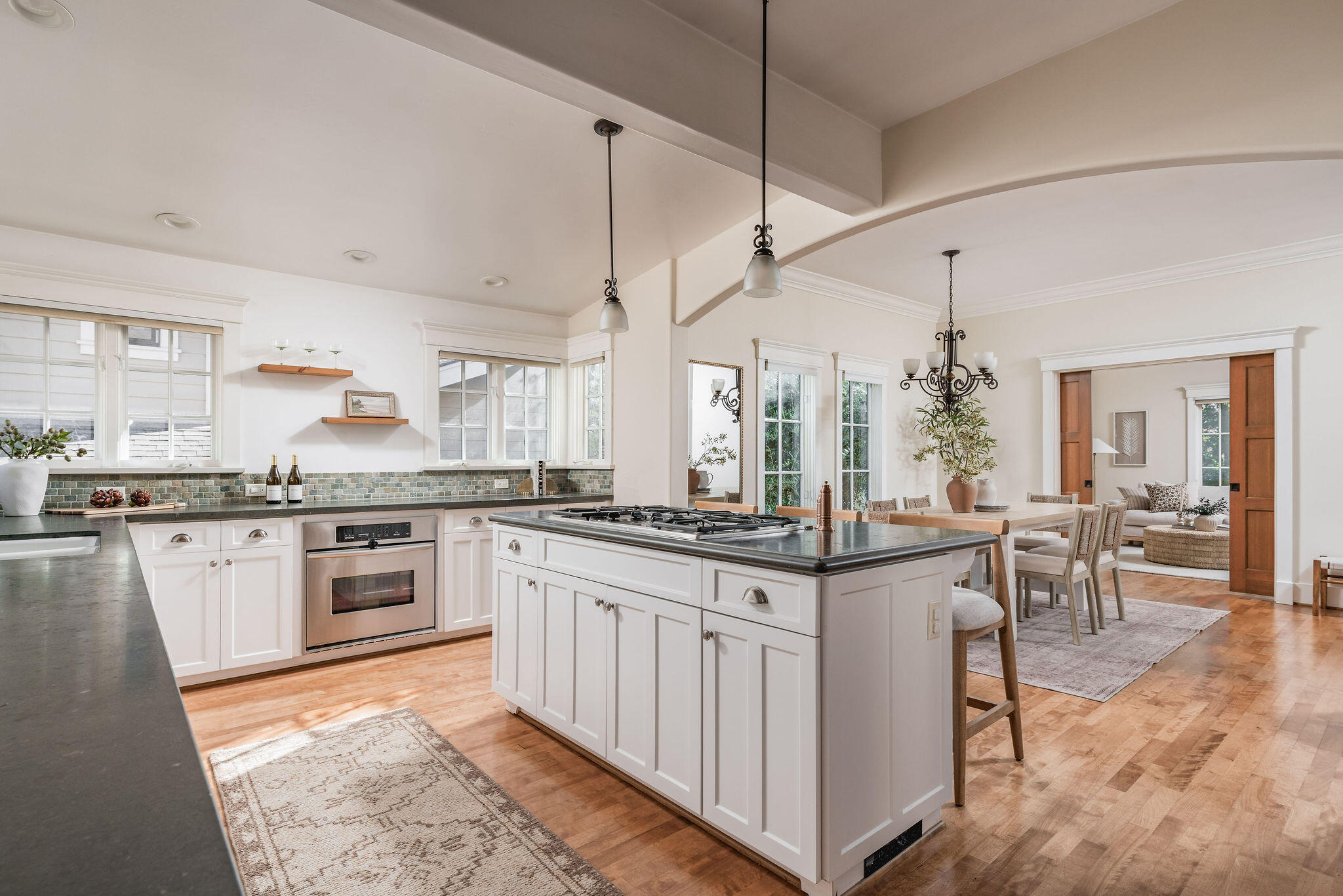 1436 Laguna Street Santa Barbara, CA 93101 - Photo 21 of 21 a kitchen with stainless steel appliances granite countertop a stove top oven a sink a dining table and chairs with white cabinets