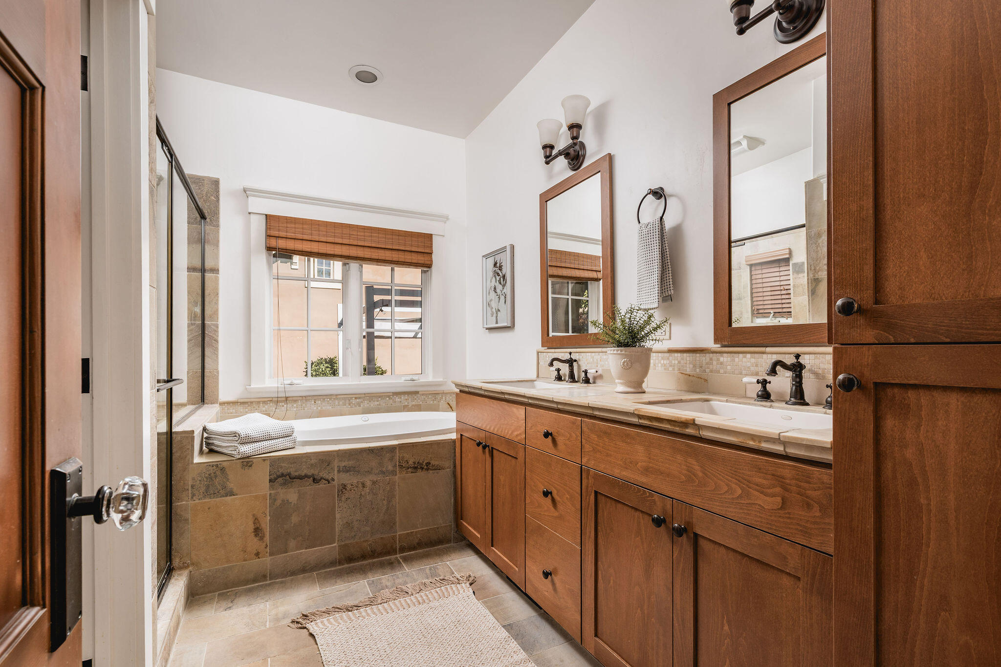 1436 Laguna Street Santa Barbara, CA 93101 - Photo 7 of 21 a large bathroom with a double vanity sink a mirror and a bathtub next to a window
