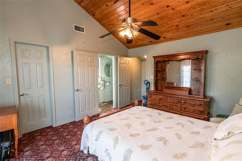 698 Storey Road Nocona, TX 76255 - Photo 30 of 34 Bedroom featuring high vaulted ceiling, wood ceiling, ceiling fan, and dark colored carpet