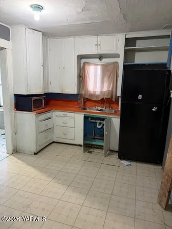 a kitchen with granite countertop a stove a microwave and a sink