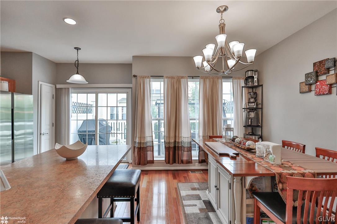 8550 Gateway Road Breinigsville, PA 18031 - Photo 12 of 50 a view of a dining room with furniture a chandelier and large windows