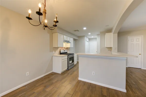 a view of a kitchen with a sink wooden floor and cabinets