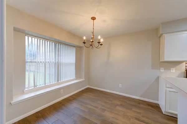 a view of a room with wooden floor and chandelier