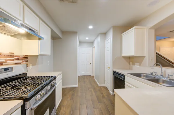 a kitchen with a sink stove top oven and cabinets