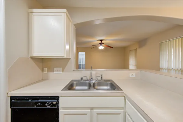 a view of a kitchen sink appliances and cabinets
