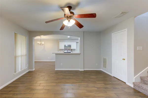 a view of empty room with wooden floor and ceiling fan