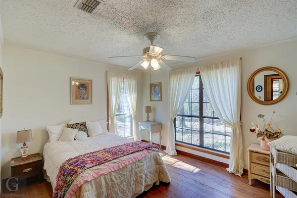 a bedroom with a bed and a chandelier fan
