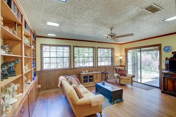 a view of a livingroom with wooden floor and a ceiling fan
