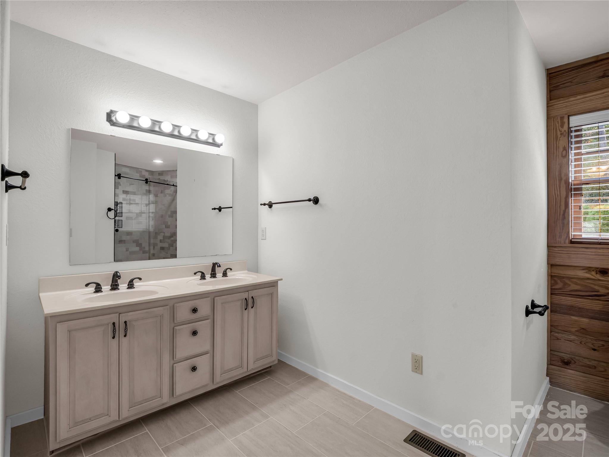 134 Raleigh Drive Lake Lure, NC 28746 - Photo 14 of 45 a spacious bathroom with a double vanity sink and mirror with shower