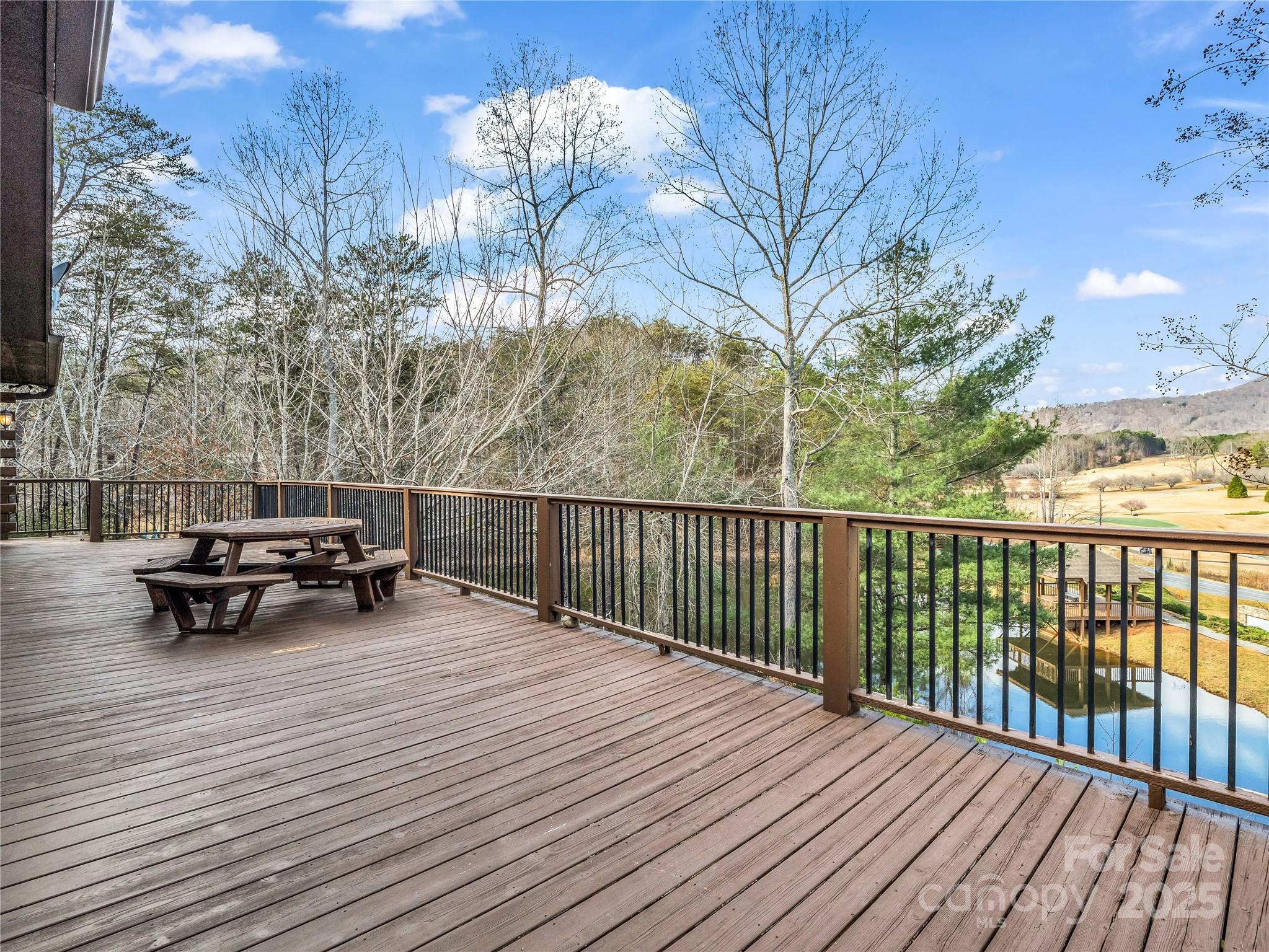 134 Raleigh Drive Lake Lure, NC 28746 - Photo 27 of 45 a view of a roof deck with table and chairs with wooden floor and fence