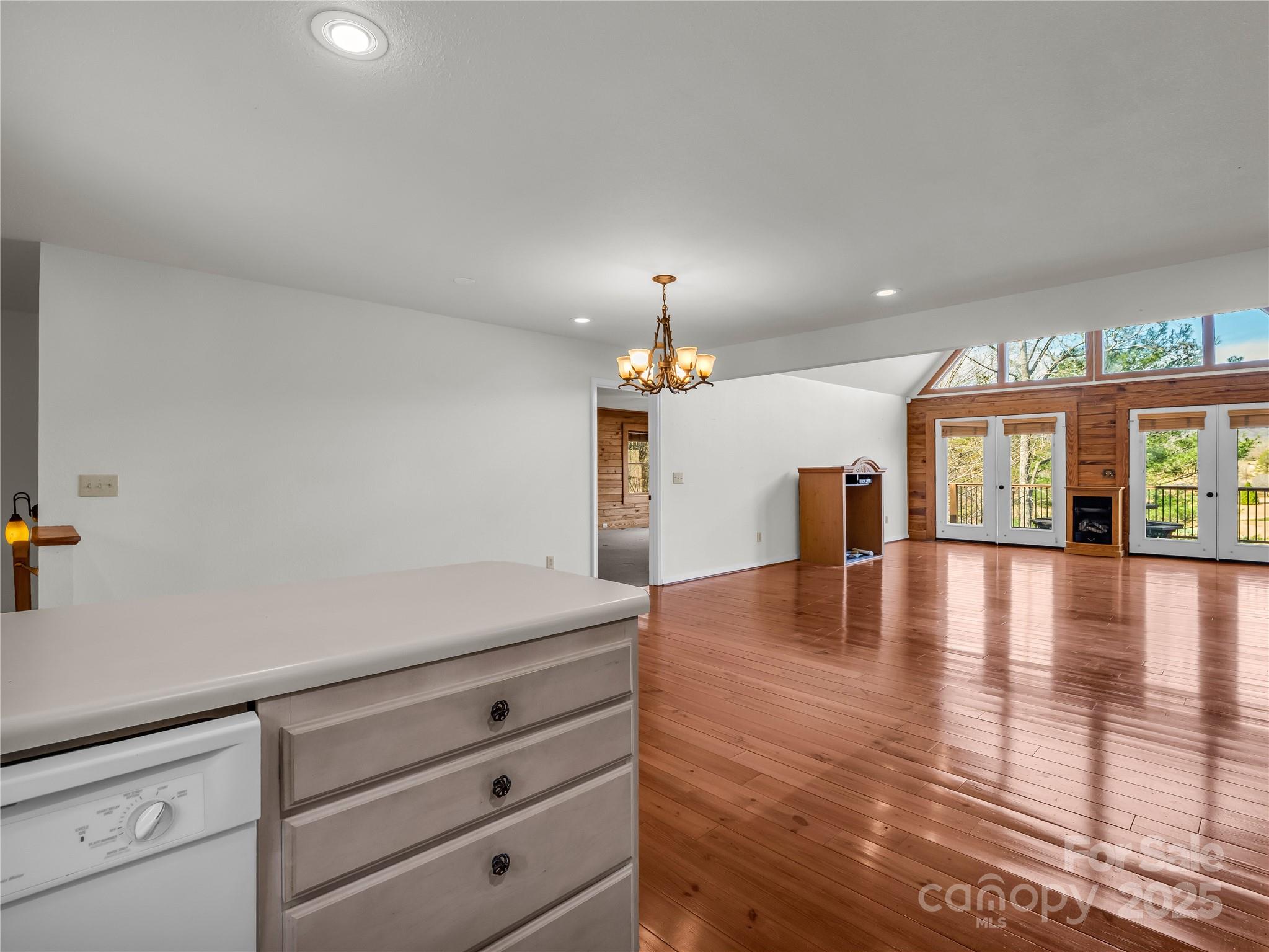 134 Raleigh Drive Lake Lure, NC 28746 - Photo 10 of 45 a view of a living room and kitchen with furniture wooden floor and chandelier