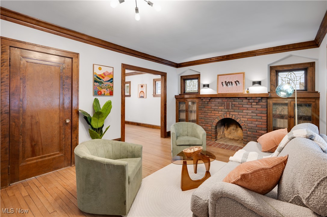 2016 Rossmoor Road Cleveland Heights, OH 44118 - Photo 9 of 46 Living area featuring crown molding, hardwood / wood-style flooring, and a brick fireplace