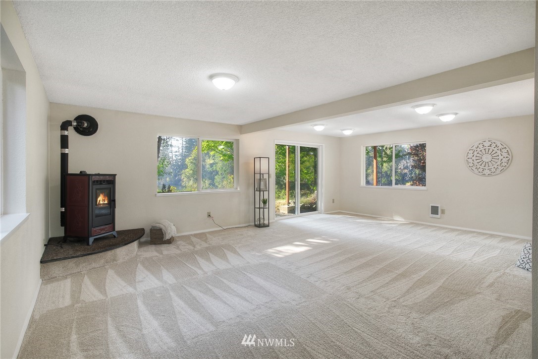19605 Whiteman Cove Road Southwest Lakebay, WA 98351 - Photo 19 of 40 a view of a big room with windows and a fireplace