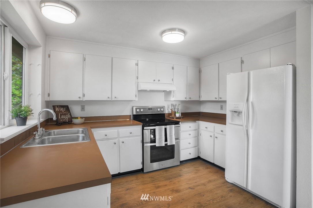 19605 Whiteman Cove Road Southwest Lakebay, WA 98351 - Photo 10 of 40 a kitchen with stainless steel appliances white cabinets and a refrigerator